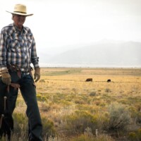 Tom Tatum on fence line repairing it in Chaps
